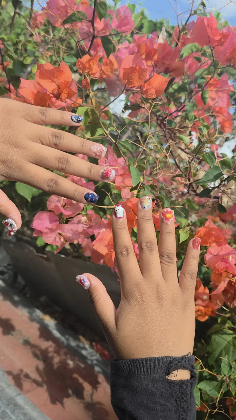 Nail art cute con charms 3D y flores sobre fondo floral