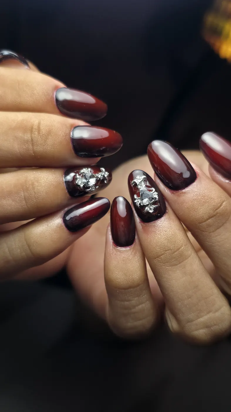 Uñas góticas en burdeos con charms plateados en 3D